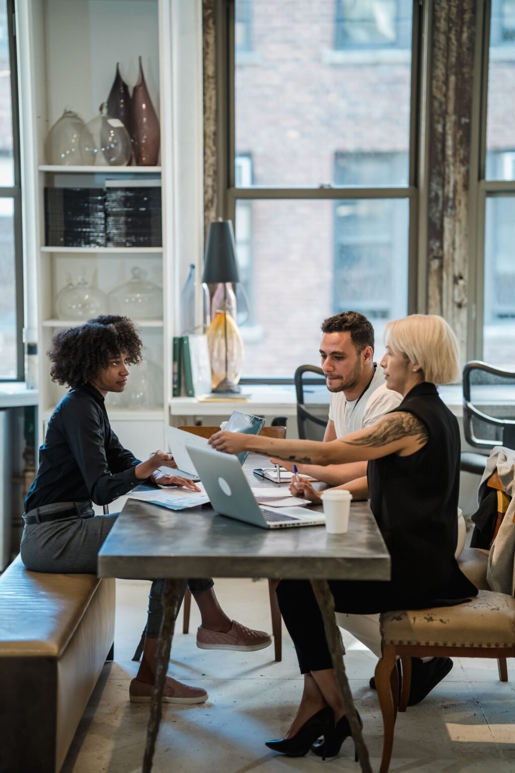Colleagues in discussion in a bright open office.