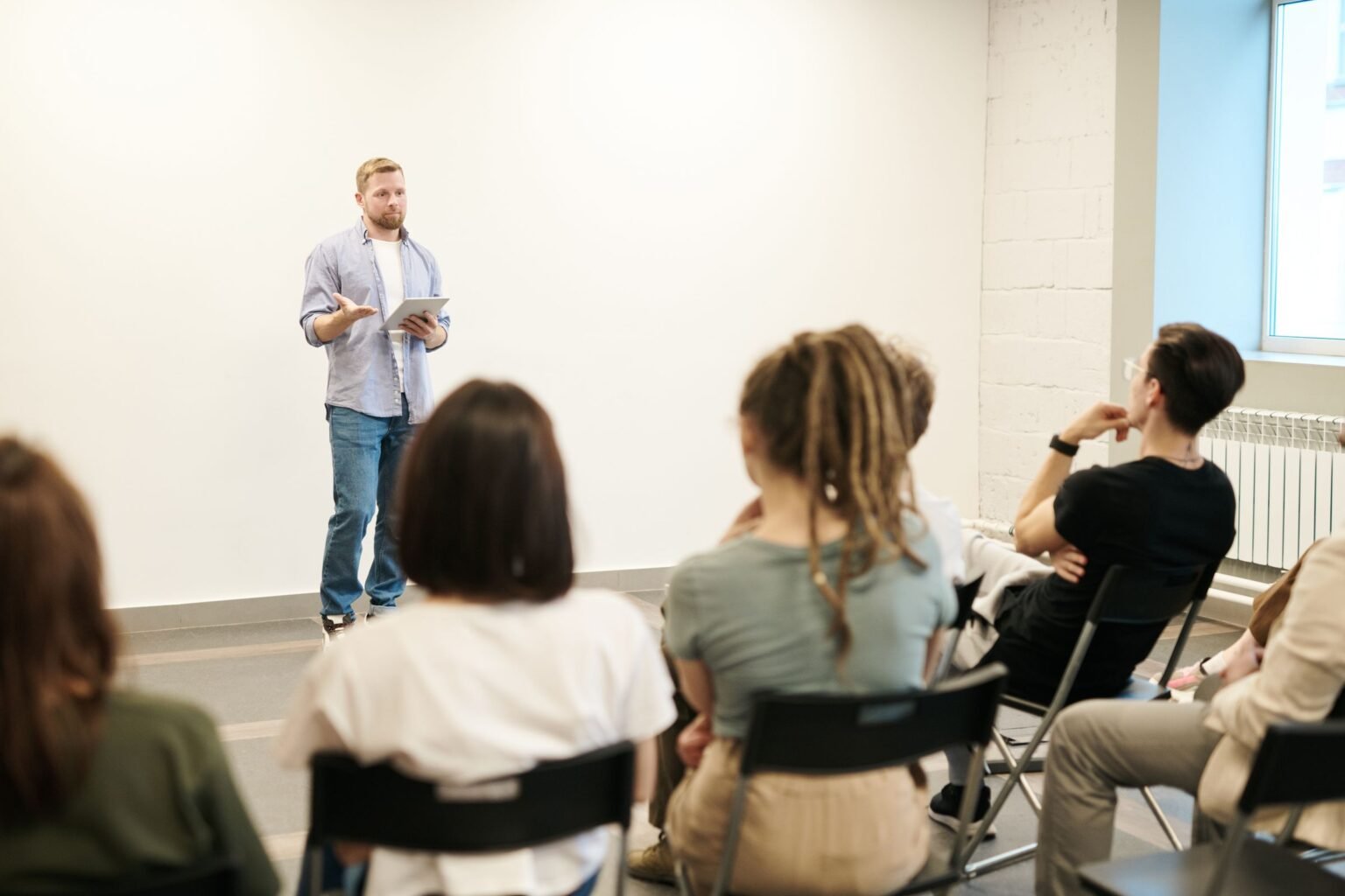 A facilitator presenting to a small seated group.