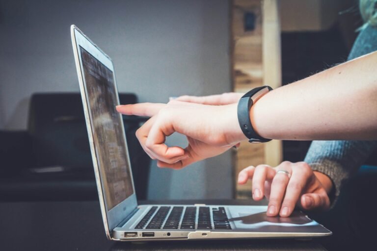 Two colleagues reviewing a document together on a laptop screen.