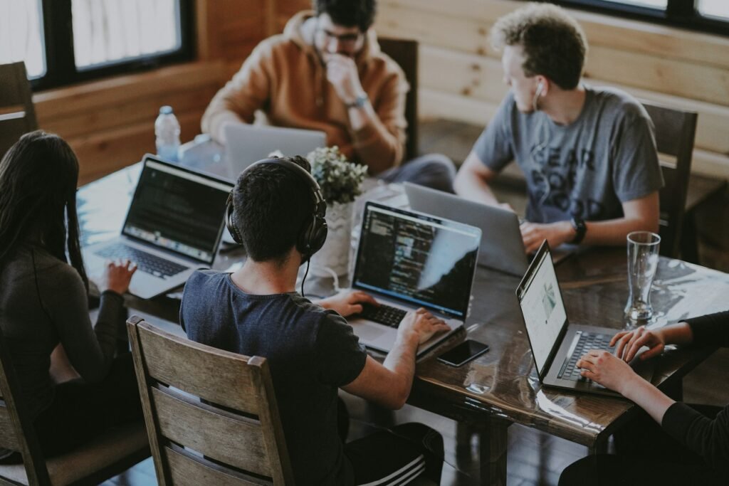 People working at laptops around a shared table.