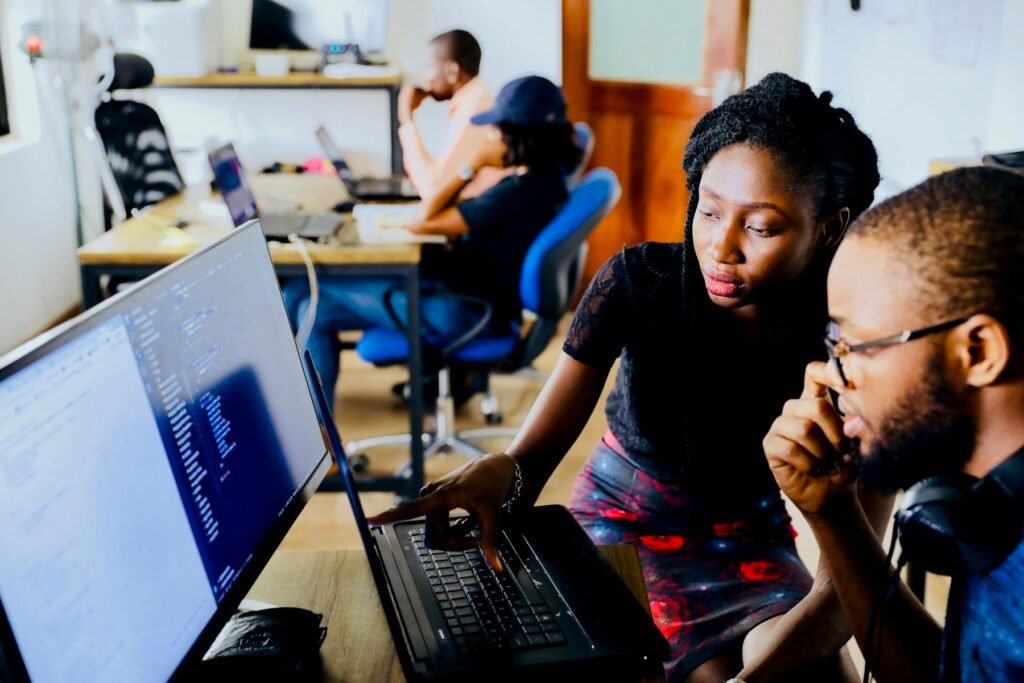 Two colleagues working through material together at a computer.